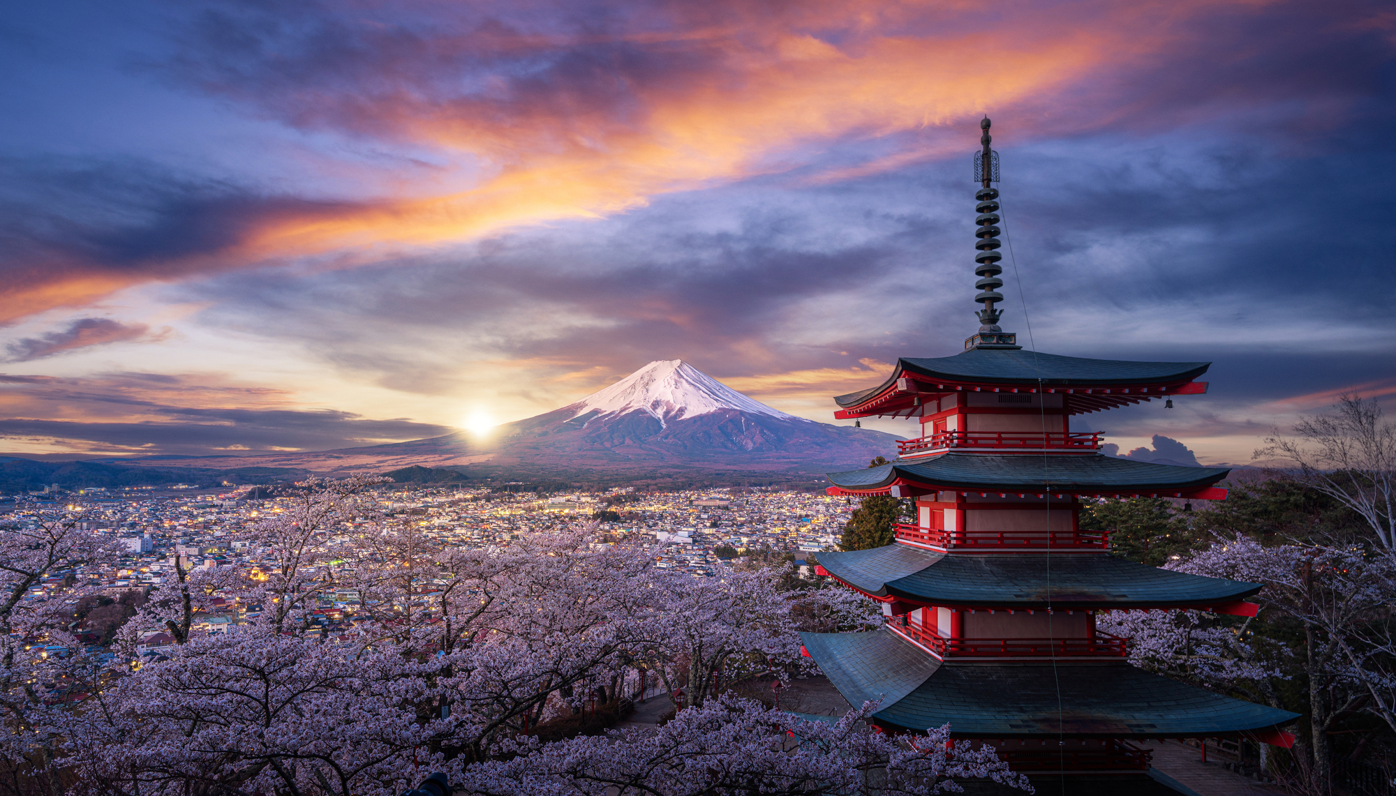 Mount Fuji with traditional pagoda and cherry blossoms at sunset